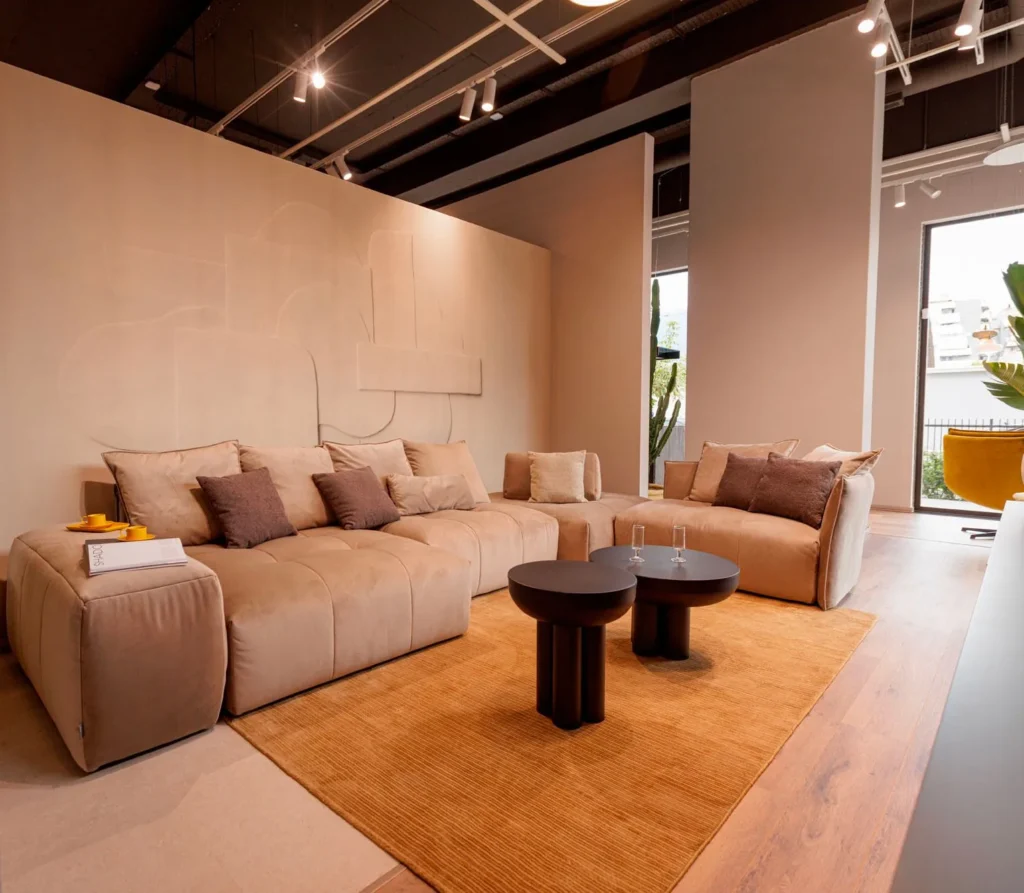 Dhomë ndenje me divan krem dhe tavolina rrethore, Showroom Tiranë